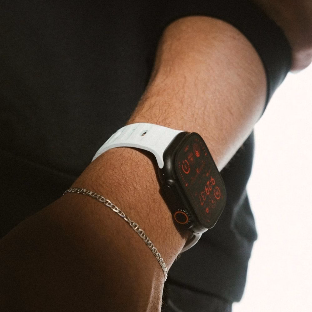 Светло-голубой ремешок Nomad Sport Band Icy Blue Glow на запястье руки в кармане, стильный вид Apple Watch Ultra 2 в повседневном образе