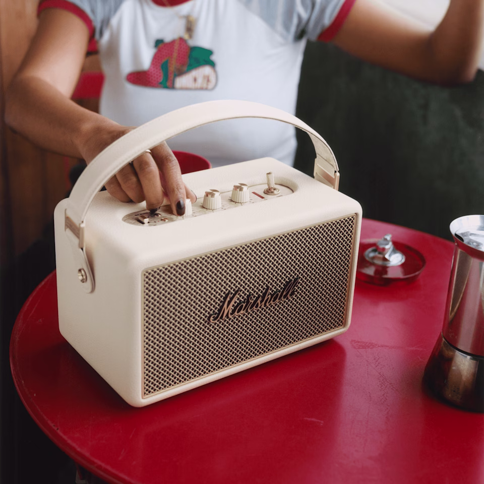 Квадратная фотография: женская рука переключает регуляторы на колонке Marshall