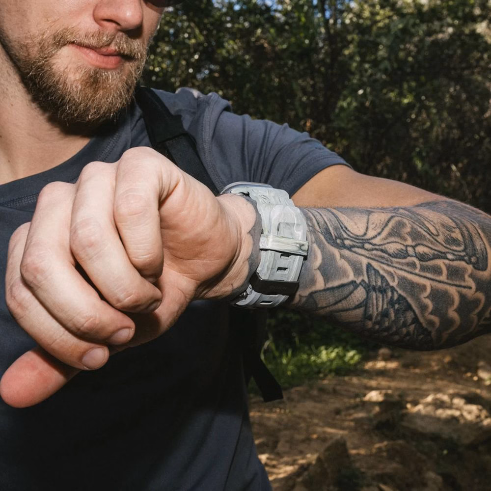 Користувач перевіряє маршрут на Apple Watch із ремінцем Nomad Rocky Point Sierra Stone під час гірського походу.