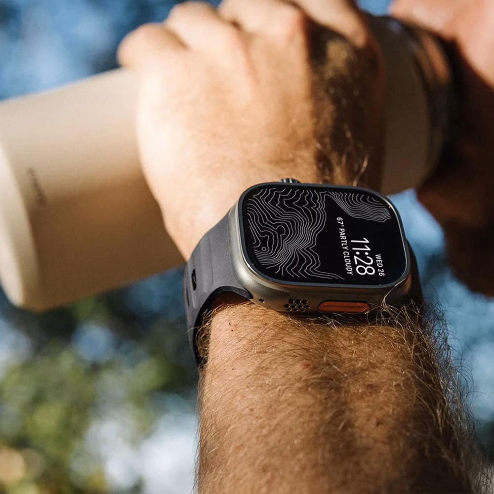 Лайфстайл-кадр: черный силиконовый ремешок Nomad Sport Band на часах Apple Watch в повседневном использовании.