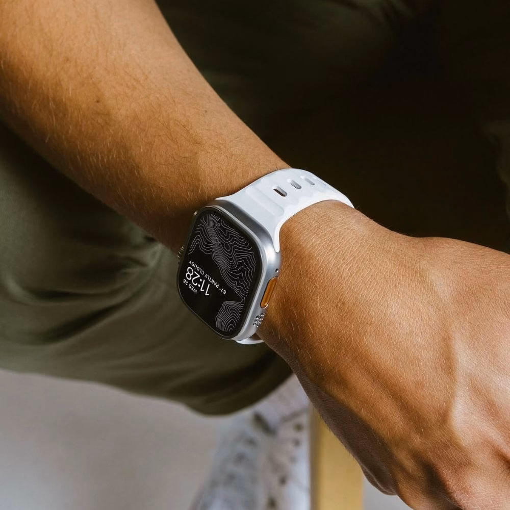 Белый ремешок для Apple Watch Ultra 2 на руке пользователя, текстурированный дизайн с перфорацией