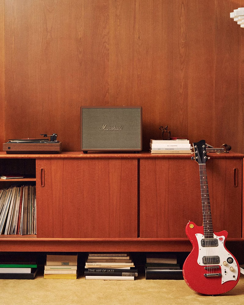 Домашня акустика Marshall Woburn 3 Brown на тумбочці поруч з гітарою